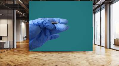 A doctor in a medical glove tosses a coin against a background of Marrs green. Symbol of choice Wall mural