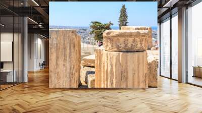 A group of people are standing around some old stone pillars Wall mural