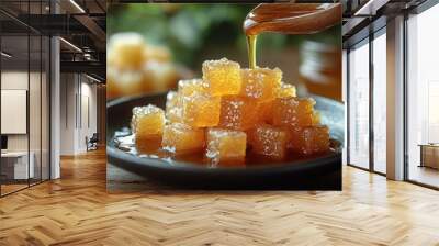 Golden honey cubes are artfully arranged on a plate, with syrup cascading over them Wall mural