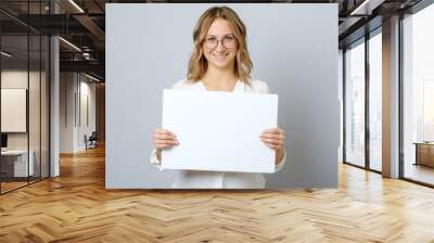 Pretty young woman holding empty blank board isolated Wall mural