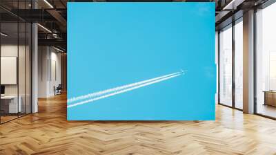 Trail of jet plane on blue sky Wall mural