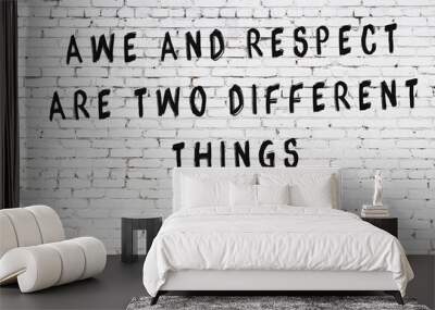 White brick wall with painted black inscription of wise quote Wall mural