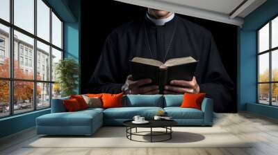 A priest dressed in a cassock holding and reading a Bible in his hands.generative ai
 Wall mural