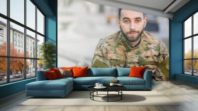 a young army soldier is smiling, a military man in a camouflage Wall mural