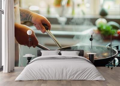 Hand of a gastronomic chef with tongs turning a piece of meat cooking in a pan on top of a ceramic hob with touch control. Wall mural