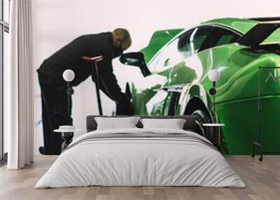 Mechanic changing the wheels of a high-end super sports car. Auto mechanic working in garage. Repair service. Wall mural