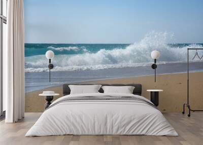 Big breaking wave on a sandy beach. Beautiful sandy beach with big sea waves on sunny summer day Wall mural