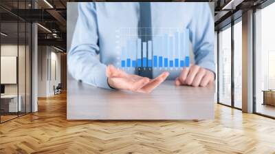 Businessman man holding a graph with positive profits growth. plan graph growth and increase of chart positive indicators in his business.more profitable and growing Wall mural