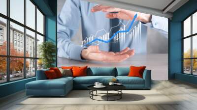 Businessman man holding a graph with positive profits growth. plan graph growth and increase of chart positive indicators in his business.more profitable and growing Wall mural