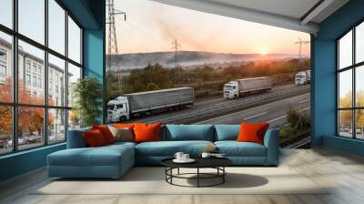 Convoy of Transportation trucks along the highway in dreamy sunset. Highway transportation with setting sun in the background Wall mural