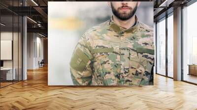 cropped shot of a bearded military man holding his hands behind his back, in camouflage on the street Wall mural