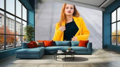 Female fashion concept. girl in a yellow coat with a beautiful m Wall mural