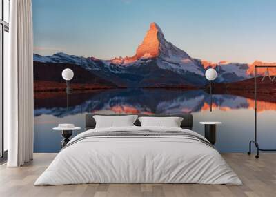 Colorful sunrise on Stellisee lake. Snowy Matterhorn peak with red light in clear water reflection. Zermatt, Swiss Alps Wall mural