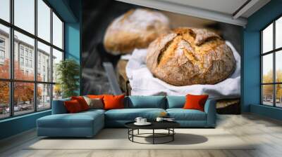 Traditional leavened sourdough bread with rought skin on a rustic wooden table. Healthy food photography Wall mural