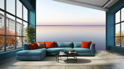 Tranquil minimalist landscape with smooth surface of the pink salt lake with calm water with horizon with clear sky in sunrise time. Simple beautiful natural calm background Wall mural