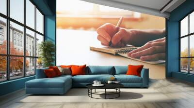 female hands with pen writing on notebook Wall mural