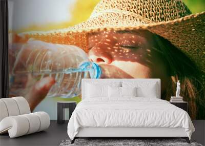 Woman drinking water in summer sunlight Wall mural