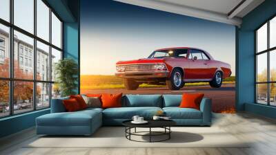 Retro red car stay on asphalt road at sunset Wall mural