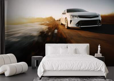 white modern car drive at asphalt road at sunset Wall mural