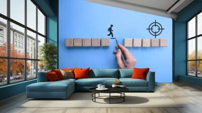 Male bussinnes man hand drawing a connecting line between two sets of wooden blocks for a silhouetted man to walk across.Conceptual of teamwork and support. Wall mural