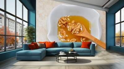 Mixture of honey and walnuts eaten by wooden spoon. Healthiest mixture Wall mural