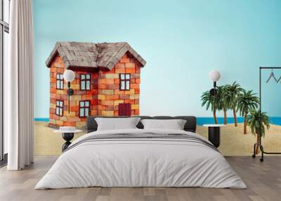 Mock up of a house in the sand. Beach house on a background of sea and blue sky. The concept of buying a home and mortgage. Palm trees and paradise island near the house. Wall mural