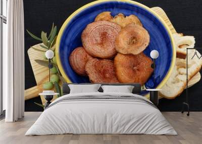 Mushrooms inside a blue ceramic bowl on a wooden table with a black background. Wall mural