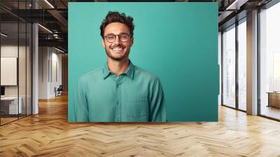 Portrait of young smiling man wearing glasses isolated on turquoise background with space for inscriptions or text.generative ai
 Wall mural