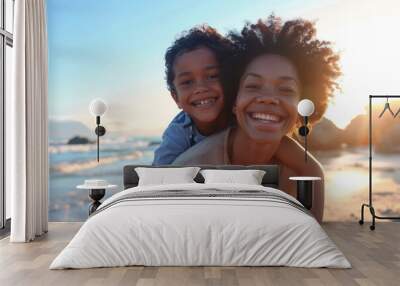 Smiling happy black mother with curly hair and baby on her back having fun on the beach in front of the camera
 Wall mural