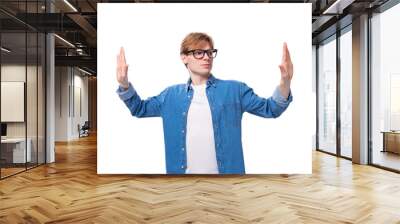 a young positive red-haired guy dressed in a blue shirt gesticulates with his hands Wall mural