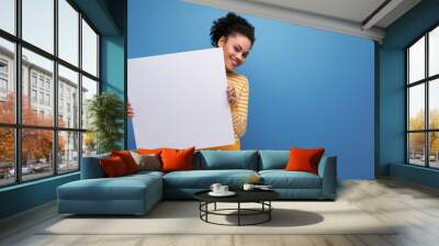 Afro brunette 20s latin young woman demonstrating paper board Wall mural