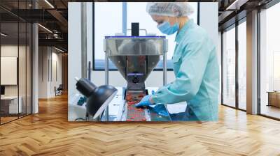 pharmacy industry woman worker in protective clothing operating production of tablets in sterile wor Wall mural