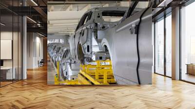 Photo of automobile production line. Modern car assembly plant. Modern and high-tech automotive industry. Conveyor of auto bodies Wall mural