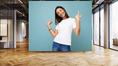 Photo of young positive happy smiling beautiful woman with sincere emotions wearing stylish clothes isolated over background with copy space Wall mural