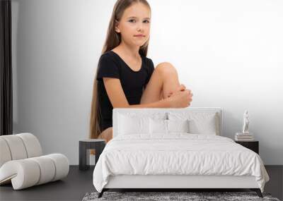 Picture of a gymnast girl sits in white short socks and black trico full height isolated on a white background Wall mural