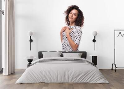 portrait of an authentic curly young brunette with shoulder-length hair dressed in a blouse on a white background with copy space Wall mural