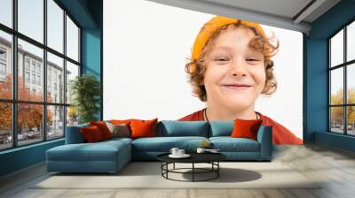 Portrait of charming boy with curly hair, yellow hat smiles isolated on white background Wall mural