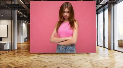 Resentful young beautiful dark blonde female person with sincere emotions isolated on background wall with copy space wearing stylish pink top. Negative concept Wall mural