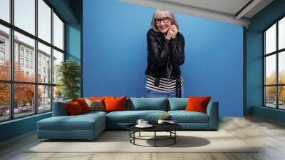 smiling gray-haired middle-aged woman in a rocker jacket on a bright background with copy space Wall mural