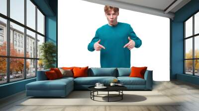 surprised caucasian young red-haired guy dressed in a blue pullover on a white background with copy space Wall mural