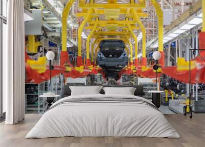 Transfer of car body. Robotic equipment makes Assembly of tcar. Modern car Assembly at factory Wall mural