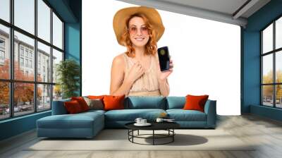 traveler girl in a summer dress with a hat and sunglasses book tickets on a smartphone on a white background with copy space Wall mural