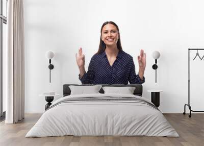 young brunette advertiser woman dressed in a blue blouse with a pattern of peas gesturing with her hands on a white background with copy space Wall mural