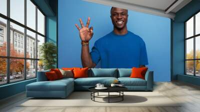 young friendly american man in a t-shirt on a blue background with copy space. people lifesal concept Wall mural