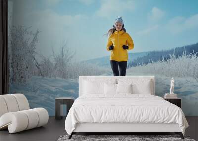 Young woman running in winter snow, listening to music with headphones, active and healthy outdoor fitness lifestyle. Space for text. Exercise and wellness. Generative AI. Wall mural