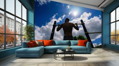 Caucasian sportsman on crossbar during street workout. Healthy lifestyle and street sport concept Wall mural