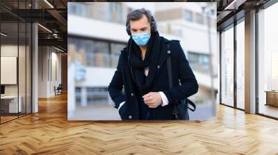 People with face mask. Concept with copy space. Portrait of adult man in quarantine of flu. Photo on the street in the city Wall mural