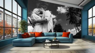 A man and a girl on the beach hugging with knives behind their backs, black and white photo Wall mural