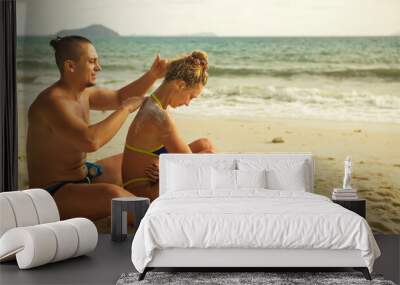 Carefree barefoot loving couple having sun block. Woman to put s Wall mural