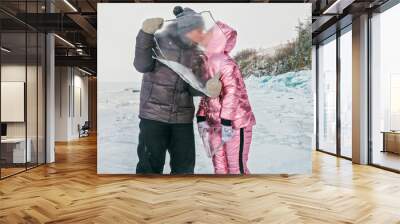 Couple has fun during winter walk against background of ice of f Wall mural